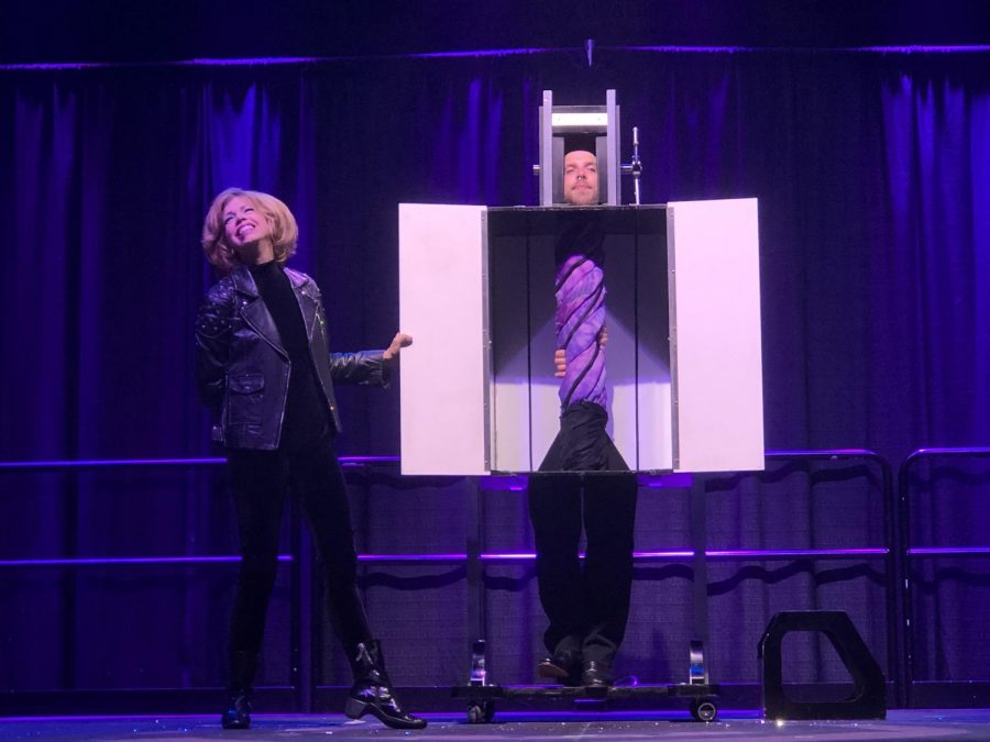 Illusionist Lyn Dillies performs a magic trick on her assistant TJ. After spinning the box around a few times, she revealed that his torso has somehow twisted.