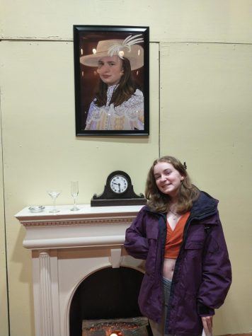 Laura Yeadon, a sophomore, poses in front of her portrait of Jack Beasley on the set of Murder Among Friends.