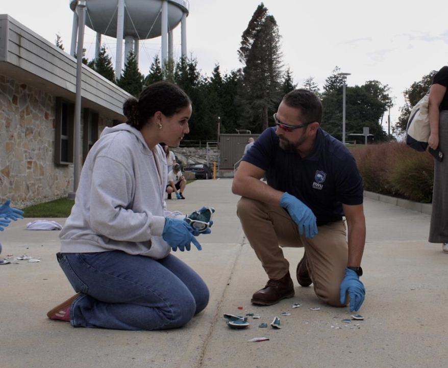 Criminal Justice Professor, Sean Gorman assists a student with their mug smashing experiment. 
