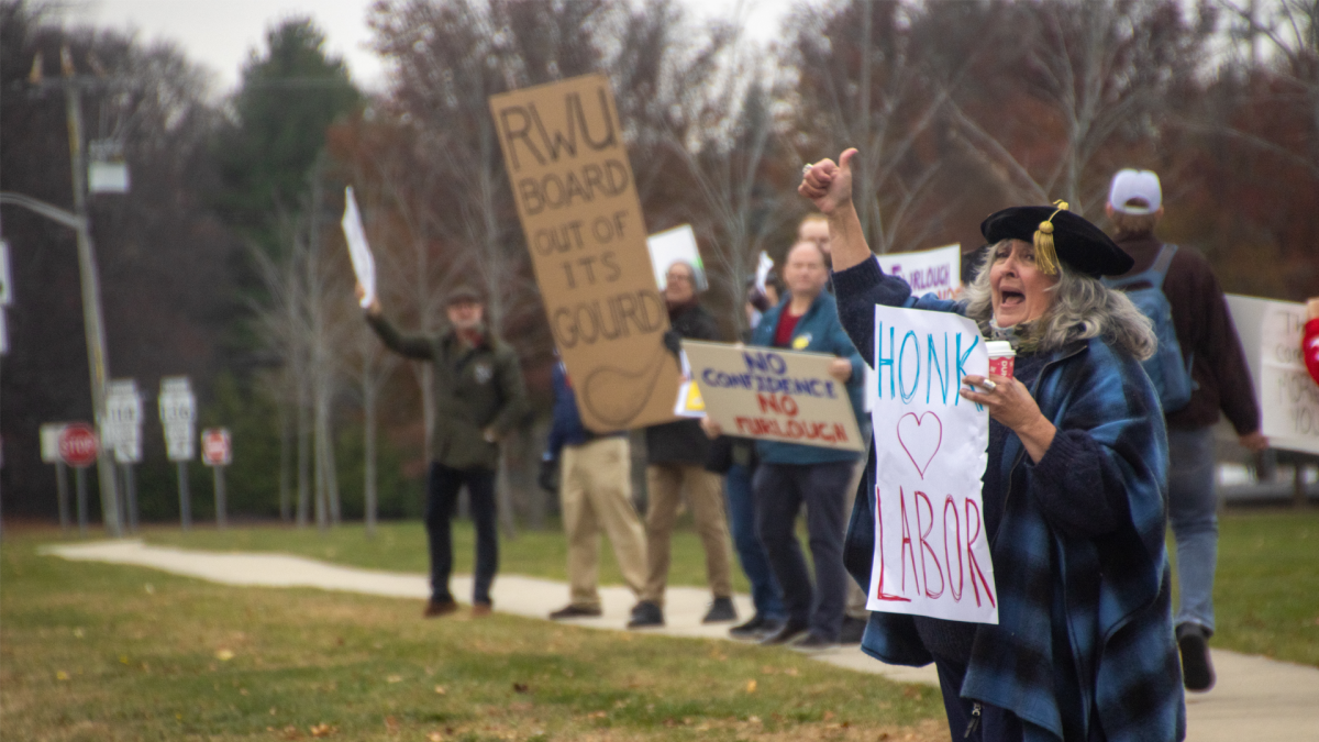 Various members of the RWU Community protesting the upcoming furloughs with signs and encouraging drivers to honk in support.
